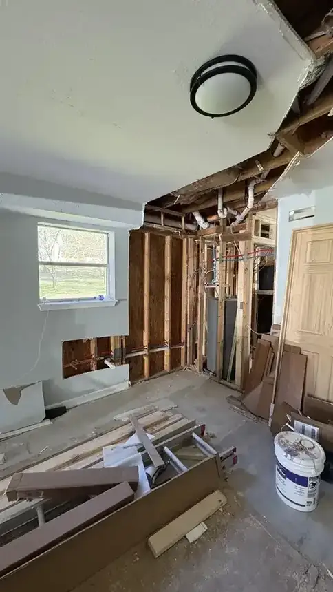 Basement apartment kitchen area with exposed framing, wall openings, and rough-in progress