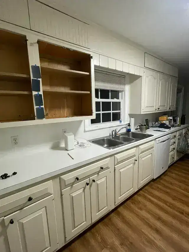 White kitchen cabinet refresh with sink, backsplash, open shelving, and counter area