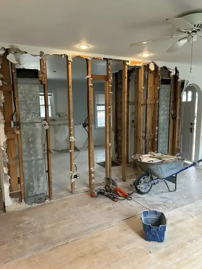 Kitchen renovation progress with exposed studs, open wall area, and rough-in condition
